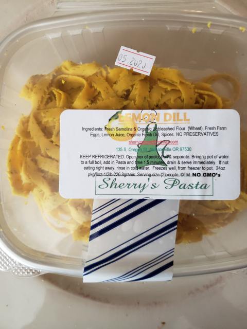 a plastic container of lemmon dill pasta with ingredients list